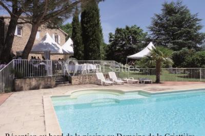 Un groupe de personnes posant debout dans une pièce avec des murs en pierre et une table en arrière-plan.