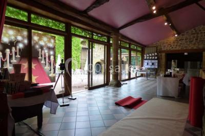 Décoration florale composée de roses, pivoines et feuillage, accrochée à une structure blanche en extérieur.