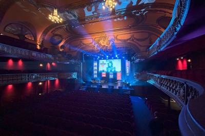 Hall spacieux avec sol en mosaïque, arches illuminées et tables décorées, éclairage chaleureux et ambiance élégante.