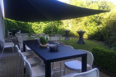 Structure de jeux en plein air avec toboggan et modules d'escalade, installée sur un sol sablonneux près d'une clôture.