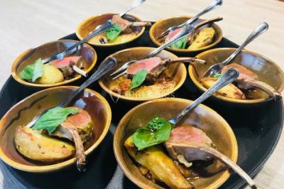 Structure de jeux en plein air avec toboggan et modules d'escalade, installée sur un sol sablonneux près d'une clôture.