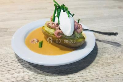 Structure de jeux en plein air avec toboggan et modules d'escalade, installée sur un sol sablonneux près d'une clôture.