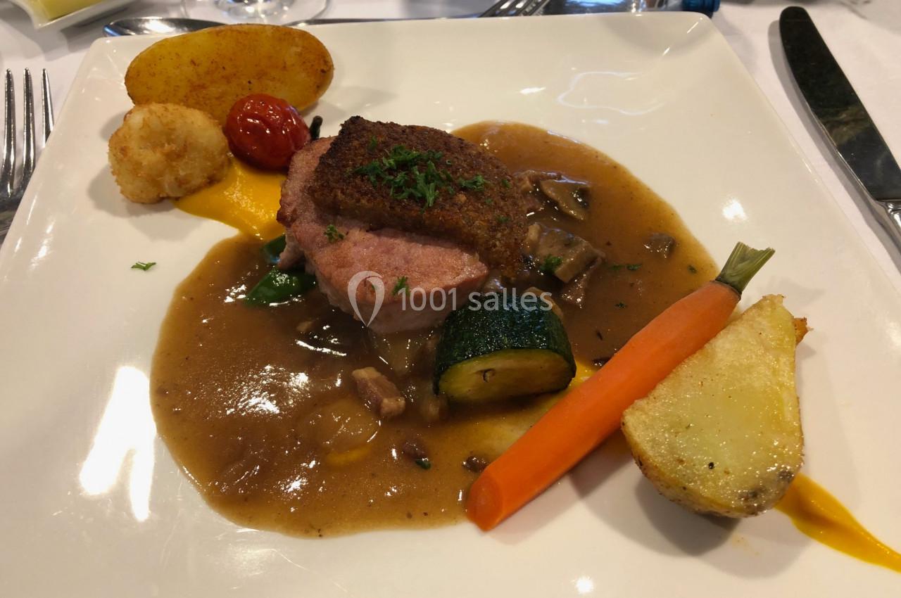 Assiette de viande garnie de légumes, sauce brune, carotte, courgette, pomme de terre et tomate cerise.