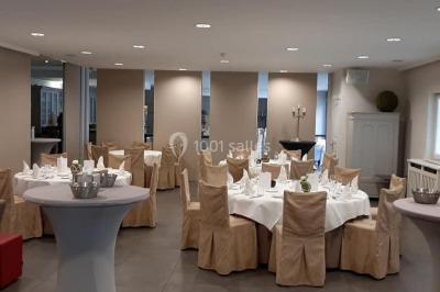 Structure de jeux en plein air avec toboggan et modules d'escalade, installée sur un sol sablonneux près d'une clôture.