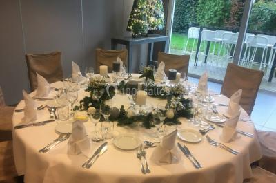 Structure de jeux en plein air avec toboggan et modules d'escalade, installée sur un sol sablonneux près d'une clôture.