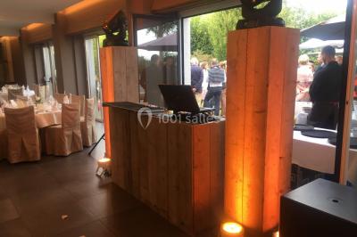 Structure de jeux en plein air avec toboggan et modules d'escalade, installée sur un sol sablonneux près d'une clôture.