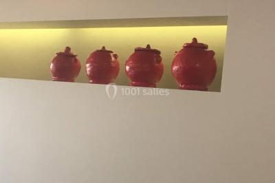 Structure de jeux en plein air avec toboggan et modules d'escalade, installée sur un sol sablonneux près d'une clôture.