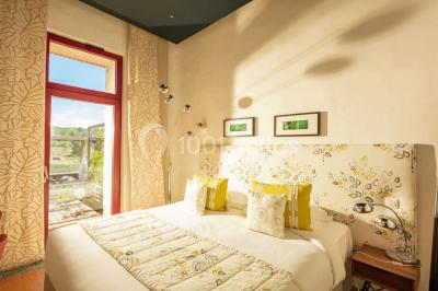 Miniature Location salle Bélesta (Pyrénées-Orientales) - Domaine Riberach #22 Bain à remous éclairé en bleu, entouré de pierres sombres, avec un panier de pétales rouges au premier plan.