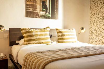 Miniature Location salle Bélesta (Pyrénées-Orientales) - Domaine Riberach #21 Bain à remous éclairé en bleu, entouré de pierres sombres, avec un panier de pétales rouges au premier plan.