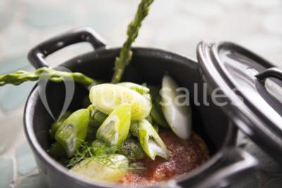 Miniature Location salle Bélesta (Pyrénées-Orientales) - Domaine Riberach #18 Bain à remous éclairé en bleu, entouré de pierres sombres, avec un panier de pétales rouges au premier plan.