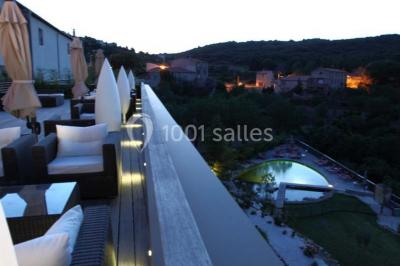 Miniature Location salle Bélesta (Pyrénées-Orientales) - Domaine Riberach #10 Bain à remous éclairé en bleu, entouré de pierres sombres, avec un panier de pétales rouges au premier plan.