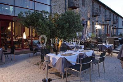 Miniature Location salle Bélesta (Pyrénées-Orientales) - Domaine Riberach #15 Bain à remous éclairé en bleu, entouré de pierres sombres, avec un panier de pétales rouges au premier plan.