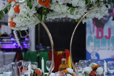 Salle de réception élégante avec des tables dressées, des verres à pied et un lustre lumineux au plafond.