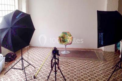Façade d'un bâtiment avec une grande fenêtre en pavés de verre, une porte ouverte et un banc blanc devant.