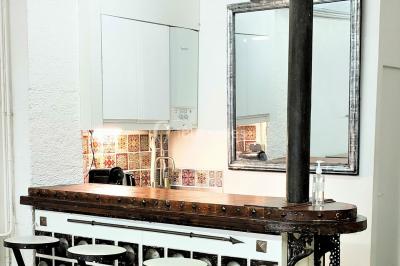 Façade d'un bâtiment avec une grande fenêtre en pavés de verre, une porte ouverte et un banc blanc devant.