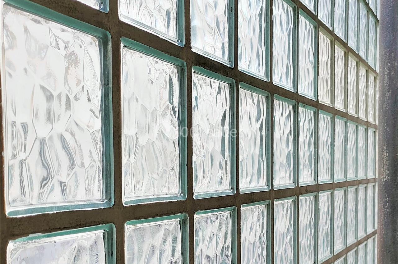 Mur composé de carreaux de verre translucides laissant passer la lumière tout en préservant l'intimité.