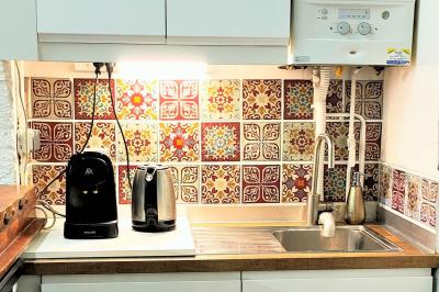 Façade d'un bâtiment avec une grande fenêtre en pavés de verre, une porte ouverte et un banc blanc devant.