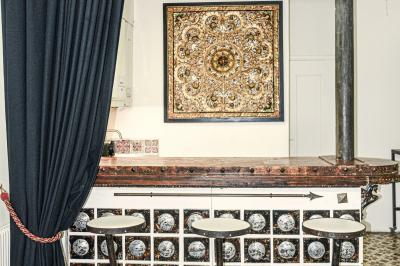 Façade d'un bâtiment avec une grande fenêtre en pavés de verre, une porte ouverte et un banc blanc devant.