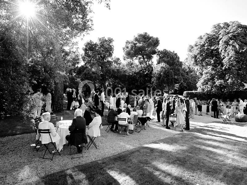 Location salle Piolenc (Vaucluse) - Château Beauchêne #6 Groupe de personnes rassemblées dans un jardin pour un événement, assises ou debout sous un ciel ensoleillé.