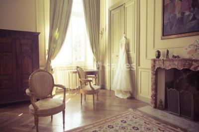 Miniature Location salle Piolenc (Vaucluse) - Château Beauchêne #12 Un couple en tenue de mariage sourit sur les marches d'un escalier en pierre devant une maison entourée de végétation.