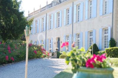 Miniature Location salle Piolenc (Vaucluse) - Château Beauchêne #4 Un couple en tenue de mariage sourit sur les marches d'un escalier en pierre devant une maison entourée de végétation.