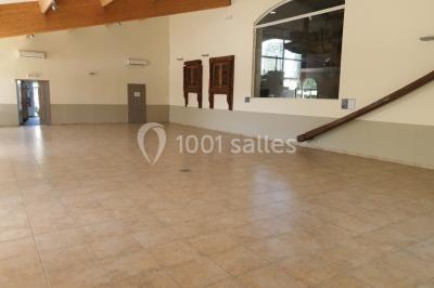 Salle avec de grandes presses anciennes en bois et une longue table dressée pour un repas.