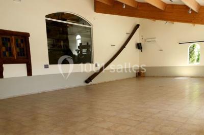 Salle avec de grandes presses anciennes en bois et une longue table dressée pour un repas.