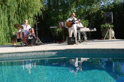 Salle avec de grandes presses anciennes en bois et une longue table dressée pour un repas.
