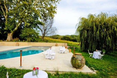 Salle avec de grandes presses anciennes en bois et une longue table dressée pour un repas.
