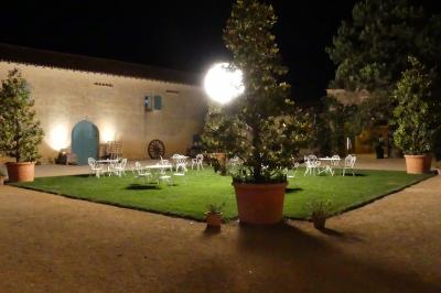 Un couple marche dans le jardin d'un château ancien entouré de verdure par une journée ensoleillée.