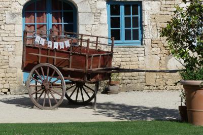Un couple marche dans le jardin d'un château ancien entouré de verdure par une journée ensoleillée.