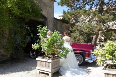 Un couple marche dans le jardin d'un château ancien entouré de verdure par une journée ensoleillée.