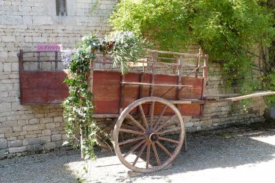 Un couple marche dans le jardin d'un château ancien entouré de verdure par une journée ensoleillée.