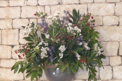 Un couple marche dans le jardin d'un château ancien entouré de verdure par une journée ensoleillée.