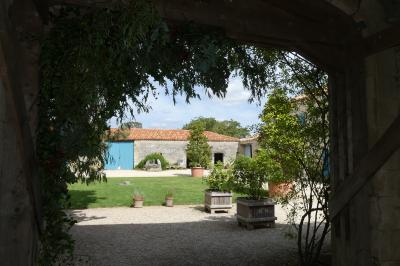 Un couple marche dans le jardin d'un château ancien entouré de verdure par une journée ensoleillée.