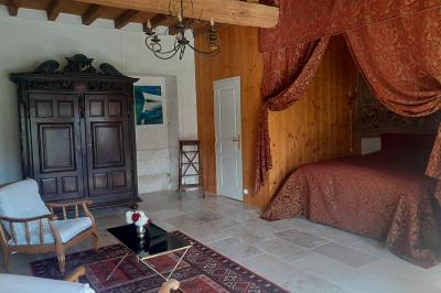 Un couple marche dans le jardin d'un château ancien entouré de verdure par une journée ensoleillée.