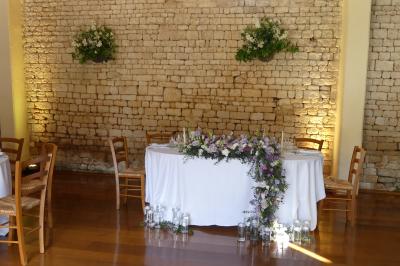 Un couple marche dans le jardin d'un château ancien entouré de verdure par une journée ensoleillée.