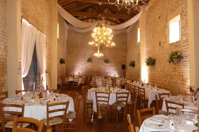 Un couple marche dans le jardin d'un château ancien entouré de verdure par une journée ensoleillée.