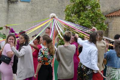 Un couple marche dans le jardin d'un château ancien entouré de verdure par une journée ensoleillée.
