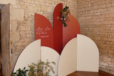 Un couple marche dans le jardin d'un château ancien entouré de verdure par une journée ensoleillée.