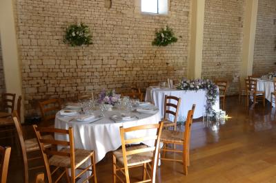 Un couple marche dans le jardin d'un château ancien entouré de verdure par une journée ensoleillée.