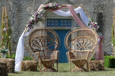 Un couple marche dans le jardin d'un château ancien entouré de verdure par une journée ensoleillée.