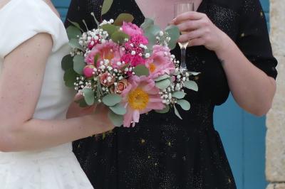 Un couple marche dans le jardin d'un château ancien entouré de verdure par une journée ensoleillée.