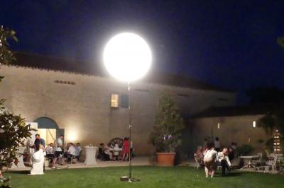 Un couple marche dans le jardin d'un château ancien entouré de verdure par une journée ensoleillée.
