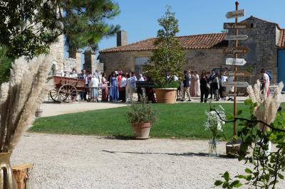 Un couple marche dans le jardin d'un château ancien entouré de verdure par une journée ensoleillée.