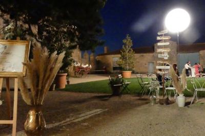 Un couple marche dans le jardin d'un château ancien entouré de verdure par une journée ensoleillée.