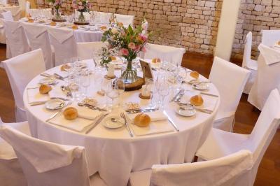 Un couple marche dans le jardin d'un château ancien entouré de verdure par une journée ensoleillée.