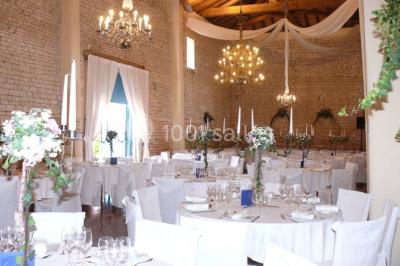 Un couple marche dans le jardin d'un château ancien entouré de verdure par une journée ensoleillée.