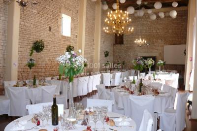 Un couple marche dans le jardin d'un château ancien entouré de verdure par une journée ensoleillée.