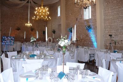 Un couple marche dans le jardin d'un château ancien entouré de verdure par une journée ensoleillée.